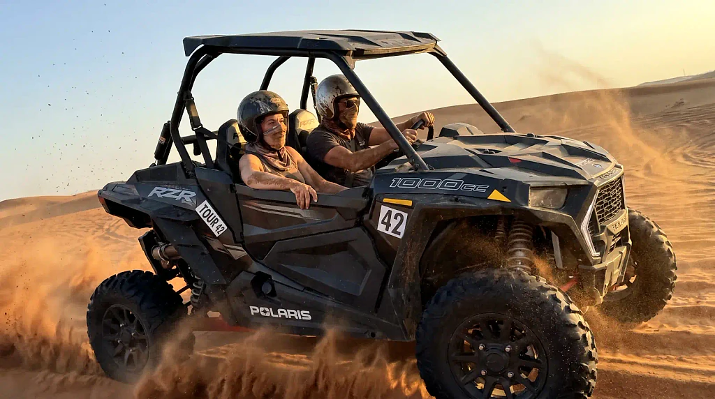 Polaris RZR buggy riding through Lahbab red dunes near Dubai