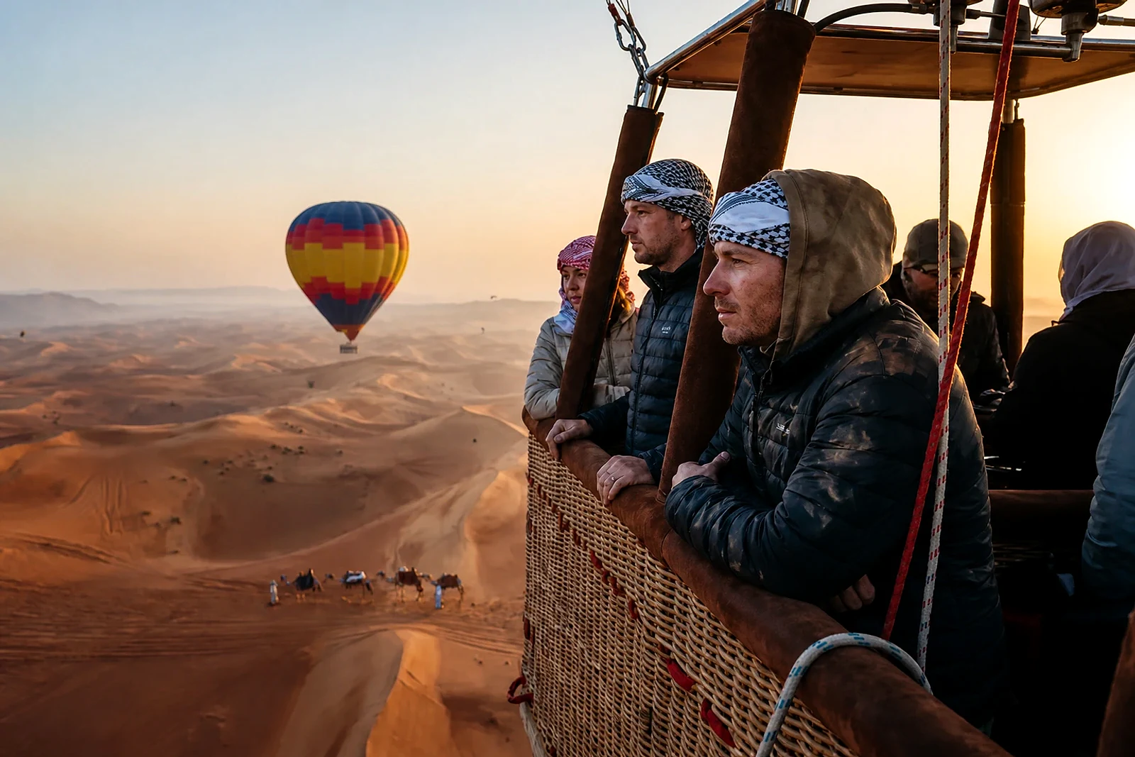 Passengers viewing the Dubai desert from a hot-air balloon basket at sunrise