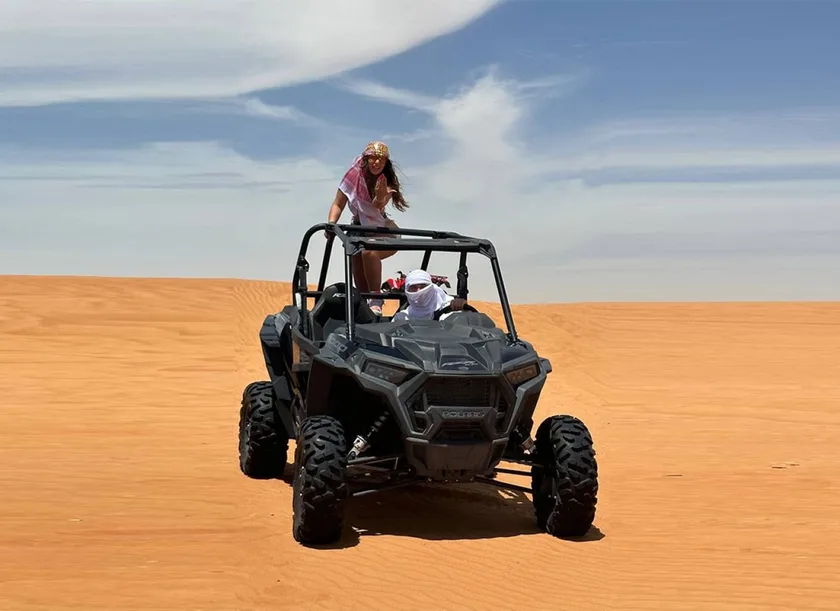 Polaris RZR dune buggy kicking up sand across the Lahbab red dunes near Dubai