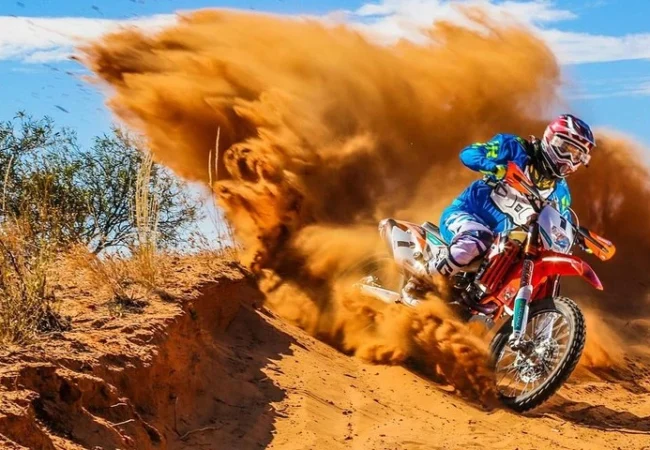 KTM dirt bike kicking up sand in the Dubai desert - Desert Buggy Rental Dubai