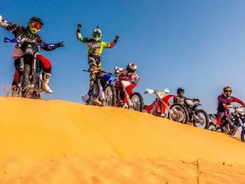 Tourists riding KTM bikes through the vast Dubai desert, exploring off-the-beaten-track locations and hidden gems