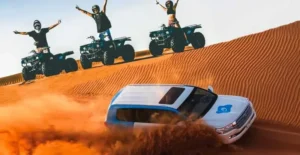 Tourists enjoying an exhilarating dune bashing experience in a 4x4 vehicle across the vast red sand dunes of the Arabian desert in Dubai