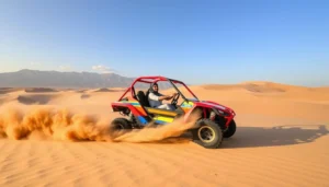 Tourists riding dune buggies across the red and gold sands of Ras Al Khaimah desert with the Hajar Mountains in the background