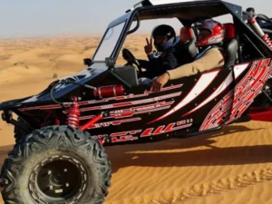 Tourists riding dune buggies across red Dubai dunes at sunset, experiencing the thrill of off-road adventure