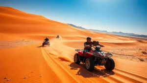 Tourists riding quad bikes across the vast, red sandy dunes of the Kyzylkum Desert in Uzbekistan under a clear sky