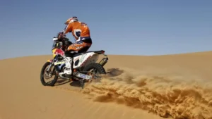 Tourists riding KTM dirt bikes across the stunning red sand dunes of Dubai's desert at high speed