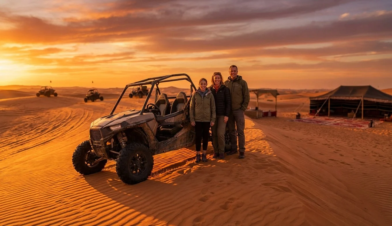 Tourists riding dune buggies across red Dubai dunes at sunset, with a lead guide in front and support vehicle following