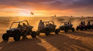 Tourists riding quad bikes across the red dunes of Ras Al Khaimah desert at sunset, with a guide leading the convoy