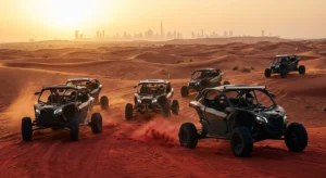 Tourists riding dune buggies across the red Lahbab dunes in Ras Al Khaimah during a VIP desert adventure tour at sunset