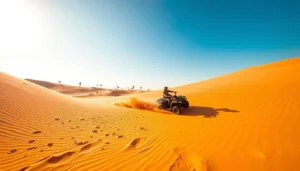 Lone rider on a quad bike carving across a huge orange sand dune in the Dubai desert