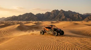 Dune buggy on desert dunes with Ras Al Khaimah mountains behind