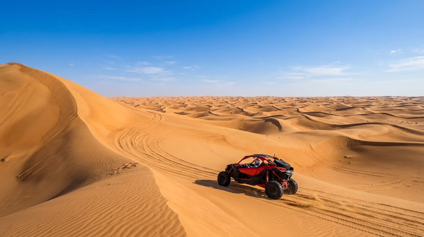 Red dune buggy on vast golden mega-dunes in the Abu Dhabi desert