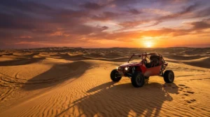 Red dune buggy on golden Dubai desert dunes at sunset