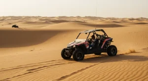 Tourist self-driving a dune buggy across golden Ras Al Khaimah desert dunes at sunset