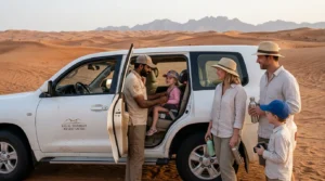 Guide securing a child in a booster seat before a RAK desert safari while parents wait beside the 4x4